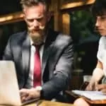 a business man and woman reviewing work on a laptop as a visual for edification