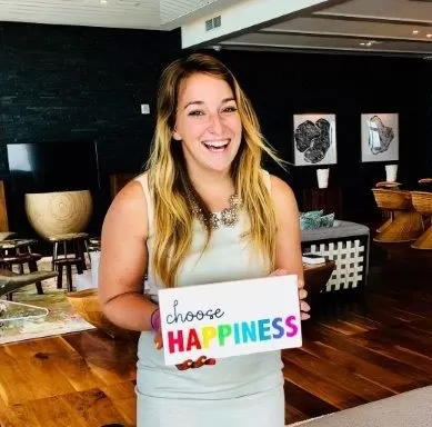 woman smiling holding a sign that reads choose happiness