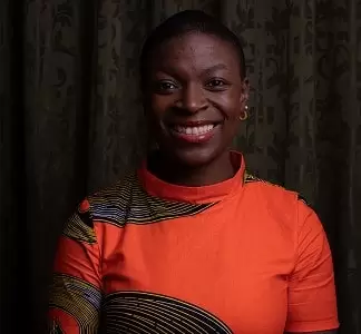 african american woman smiling in an orange dress